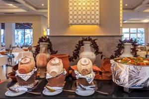 Restaurant im Djerba Holiday Beach Hotel mit verschiedenen Speisen und Geschirr.