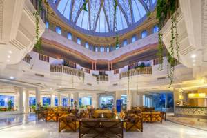 Lobby des Djerba Holiday Beach Hotels mit Kuppel, gelben Sesseln und Pflanzen