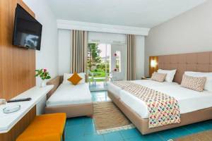 Djerba Holiday Beach Hotelzimmer mit zwei Betten, Fernseher und Gartenblick.