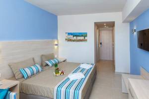 Doppelbettzimmer im Irene Palace Beach Resort Hotel mit blauen Wänden und Bettwäsche.