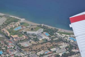 Luftaufnahme des Irene Palace Beach Resorts mit Blick auf die Küste und mehrere Gebäude, darunter Pools.
