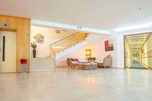 Empfangsbereich des Irene Palace Beach Resorts mit modernem Design, Treppen, Sofas und Dekor.