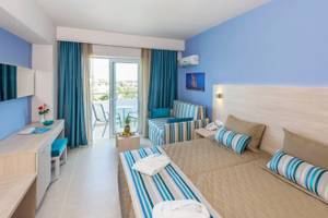 Zimmer im Irene Palace Beach Resort mit Blick auf den Balkon und Gartenmöbel.