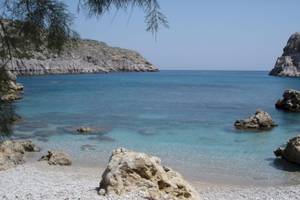 Strand des Irene Palace Beach Resorts mit kristallklarem Wasser und Felsen