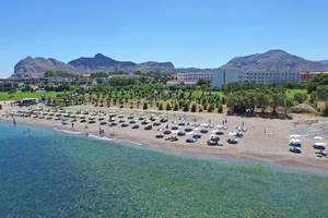 Luftaufnahme des Irene Palace Beach Resorts mit vielen Sonnenschirmen und Liegen am Strand