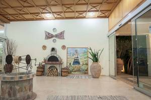 Innenbereich des Irene-Palast-Strandresorts mit Eingang, Ofen, Pflanzen und Wanddekorationen.