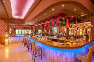 Bar im Irene Palace Beach Resort Hotel mit blauen Lichtern und Holztheke.