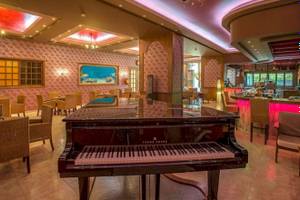 Bar im Irene Palace Beach Resort mit Klavier und farbiger Beleuchtung.