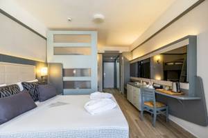 Hotelzimmer im VONRESORT Golden Coast mit Bett, Schreibtisch und Fernseher.