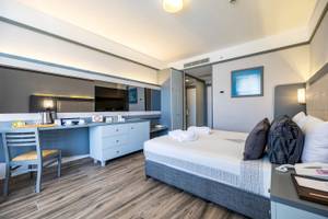 Hotelzimmer im VONRESORT Golden Coast mit Bett, Schreibtisch und Fernseher.