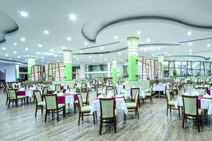 Restaurant im VONRESORT Golden Coast mit grünen Säulen und Holzboden