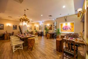 Innenbereich des Restaurants im VONRESORT Golden Coast mit Holztischen, Stühlen und dekorativen Elementen.