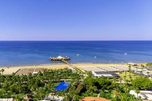 Luftaufnahme des VONRESORT Golden Coast am Strand mit Meer, Palmen und Gebäuden.