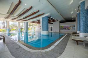 Innenpool des VONRESORT Golden Coast mit blauen Säulen und Sonnenliegen.