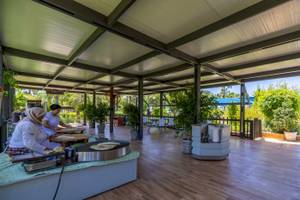 Zwei Frauen bereiten Essen auf der Terrasse des VONRESORT Golden Coast zu.
