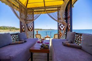 Terrasse des VONRESORT Golden Coast mit Blick auf das Meer und Sonnenschirm.