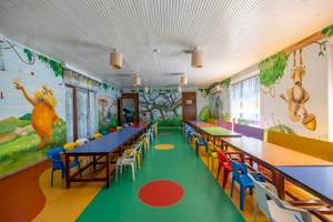 Kinderzimmer im VONRESORT Golden Coast mit grünem Boden und bunten Wandmalereien.