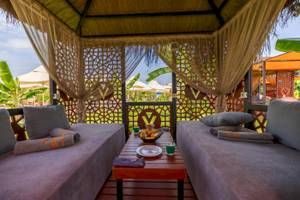 Lounge-Bereich im VONRESORT Golden Coast mit zwei Betten, Kissen und einem Tisch mit Obst.