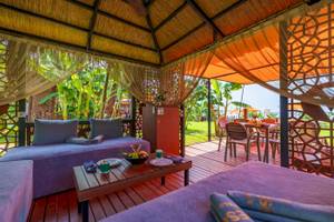 Terrasse im Vonresort Golden Coast mit Sofas, Tisch und Früchten