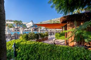 Außenbereich des VONRESORT Golden Coast mit Pool, Sonnenschirmen und Liegestühlen.