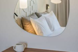 Ein Hotelzimmer im Georgioupolis Resort Aquapark & SPA mit einem Bett, das in einem Spiegel reflektiert wird.