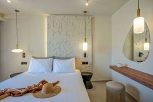 Hotelzimmer im Georgioupolis Resort Aquapark & SPA mit Bett, Hut und Möbeln.