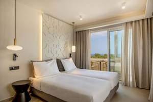 Doppelbett-Zimmer im Georgioupolis Resort Aquapark & SPA mit Balkon und Meerblick.
