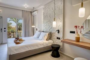 Innenansicht eines Schlafzimmers im Georgioupolis Resort Aquapark & SPA mit Bett, Dekor und Terrassenzugang.