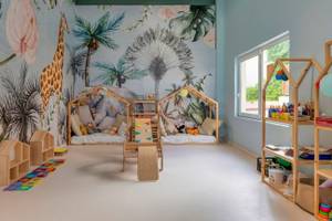 Kinderzimmer im Georgioupolis Resort Aquapark & SPA mit tropischen Wandmalereien und Spielzeug.