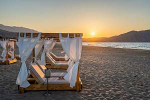 Strandbetten im Georgioupolis Resort Aquapark & SPA bei Sonnenuntergang