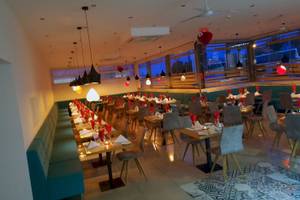 Innenbereich des Georgioupolis Resort Aquapark & SPA mit vielen gedeckten Tischen und roten Herzen an der Decke.