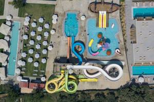 Luftaufnahme des Georgioupolis Resort Aquapark & SPA mit Pools, Rutschen und Sonnenschirmen.