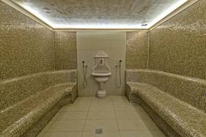 Saunaraum im Georgioupolis Resort Aquapark & SPA mit gefliesten Wänden und Bänken.