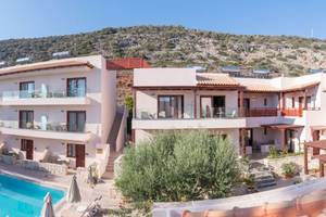 Außenansicht des Cactus Village Hotel & Bungalows mit Swimmingpool und Berg im Hintergrund.