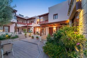 Außenbereich des Cactus Village Hotel & Bungalows mit Gehweg, Pflanzen und Gebäuden.