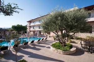 Pool-Lounge-Bereich des Cactus Village Hotel & Bungalows mit Liegen und Sonnenschirmen.