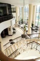 Innenansicht des Radisson Blu Hotel & Resort, Abu Dhabi Corniche mit einer großen Kristallleuchte und einer Wendeltreppe.