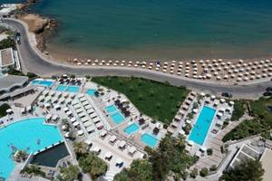 Oberflächenansicht des The Island Hotel auf Kreta mit mehreren Swimmingpools, Liegen und Sonnenschirmen.