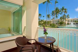 Balkon des JOIA Bávaro by Iberostar Hotels mit Blick auf einen Swimmingpool und Palmen.