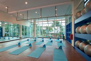 Fitnessstudio im Iberostar Grand Bavaro mit blauen Yogamatten und großen Fenstern.