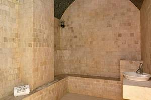 Sauna im JOIA Bávaro by Iberostar Hotel mit Steinwänden und Sitzbank.