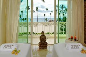 Spa-Behandlungsraum im Hotel JOIA Bávaro by Iberostar mit Blick auf das Meer und Palmen.