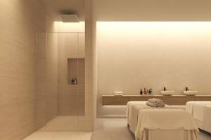 Massageraum im Jaz Elite Amara Hotel mit zwei Massagebetten, Dusche und Waschbecken.