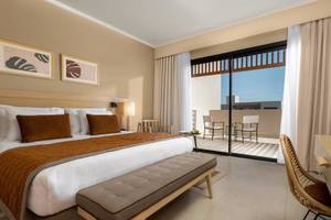 Hotelzimmer im Jaz Elite Amara mit großem Bett, Balkon und Stadtblick.