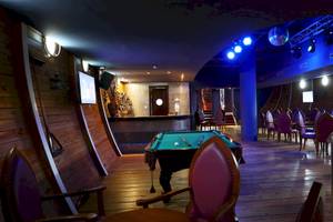 Pool-Lounge im JOIA Bávaro Hotel mit grünem Billardtisch und blauer Beleuchtung.