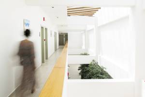 Foto von einem langen Flur im Almyrida Beach Hotel mit weißen Wänden, einem hölzernen Boden und Pflanzen