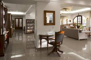 Empfangsbereich des Almyrida Beach Hotels mit gefliestem Boden, Couch, Tisch und Bücherregal.