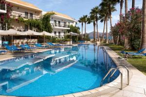 Außenbereich des Almyrida Beach Hotel mit Pool und Liegestühlen.