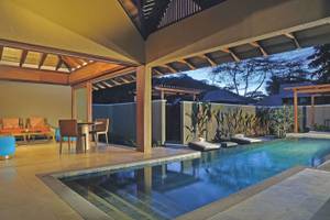 Pool-Bereich im Constance Ephelia Resort mit Sitzmöbeln und Sonnenliegen.