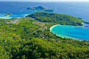 Luftaufnahme des Constance Ephelia Resorts auf einer Insel mit türkisfarbenem Wasser und grüner Vegetation.